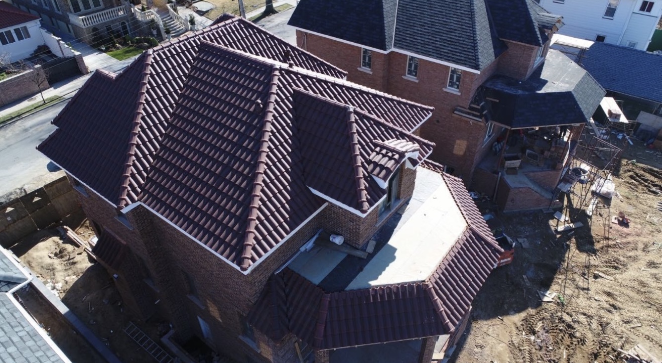 Craftsmen hand-laying maroon mission barrel clay tile